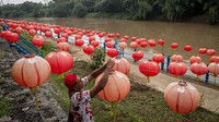 Warga memasang hiasan lampion menyambut Tahun Baru Imlek 2022 di Taman Sunan Jogo Kali pinggir Sungai Bengawan Solo, Pucang Sawit, Solo, Jawa Tengah, Kamis (27/1/2022).
