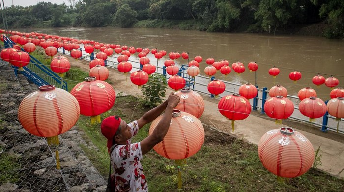 Sambut Imlek, Lampion Hiasi Tepi Sungai Bengawan Solo Warga memancing ikan di pinggir Sungai Bengawan Solo yang dihiasi lampion menyambut Tahun Baru Imlek 2022 di Taman Sunan Jogo Kali, Pucang Sawit, Solo, Jawa Tengah, Kamis (27/1/2022). Hiasan lampion di tepi Sungai Bengawan Solo tersebut selain untuk menyambut Tahun Baru Imlek 2022 juga sebagai upaya mengenalkan wisata bantaran sungai dan mengajak masyarakat menjaga kelestarian sungai. ANTARA FOTO/Mohammad Ayudha/wsj.