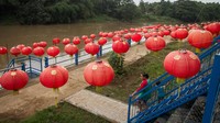 Warga melintas di pinggir Sungai Bengawan Solo yang dihiasi lampion menyambut Tahun Baru Imlek 2022 di Taman Sunan Jogo Kali, Pucang Sawit, Solo, Jawa Tengah.