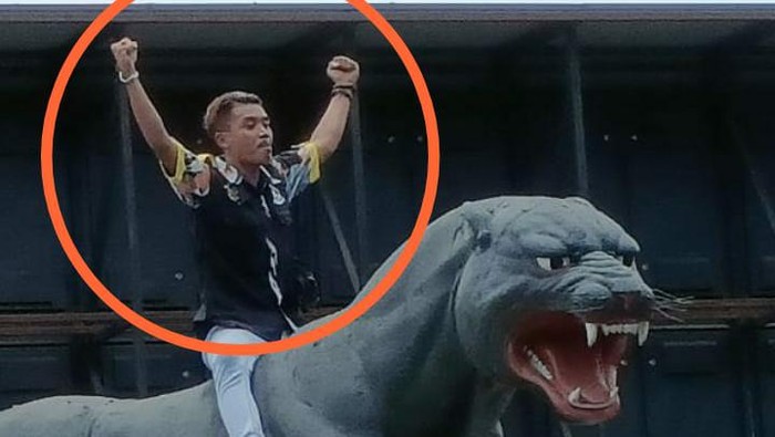 Seorang anggota ormas GMBI yang menunggangi patung Macan Lodaya kini diburu polisi