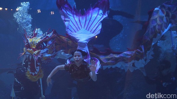 Penyelam melakukan atraksi liong menari bersama putri duyung saat pertunjukan mini opera bawah air di Jakarta, Kamis (27/1/2022).