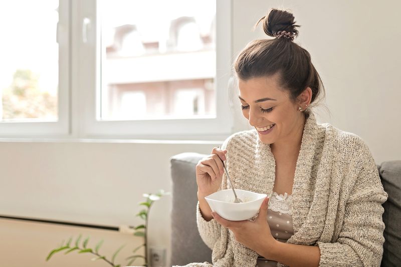 Young woman eating an oatmeal in the morning. Healthy lifestyle concept.