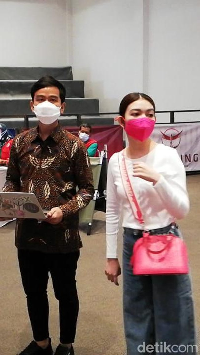 Gibran tampil formal dengan berbatik, sementara Selvi memilih look yang lebih kasual dengan padanan kaus putih lengan panjang dan wide-leg jeans. (Foto: Ari Purnomo/detikcom)