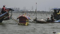 Sejumlah nelayan dan warga melarung (menghanyutkan) sesaji di laut Tarumajaya, Kabupaten Bekasi, Jawa Barat.