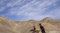 Anak kecil mendorong troli pembawa air bersih di Kamar Kalagh, Herat, Afghanistan, (26/11/2021). Bermain bersama tanpa gawai seperti ini sangat menyenangkan. (AP Photo/Petros Giannakouris)