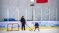 Seorang pelatih membimbing seorang pemain muda melalui latihan selama sesi latihan di arena hoki di Beijing, Jumat, (14/1/2022). Olimpiade Musim Dingin Beijing memberi manfaat dan mendorong minat di kalangan orang Cina dalam bermain ski, skating, hoki, dan olahraga musim dingin lainnya yang sebelumnya tidak dikenal. Ini juga menciptakan peluang bisnis baru. (AP/Mark Schiefelbein)