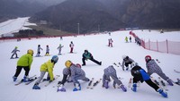 Anak-anak sekolah melakukan pemanasan sebelum pelajaran ski di Resor Ski Vanke Shijinglong di Yanqing di pinggiran Beijing, Cina.