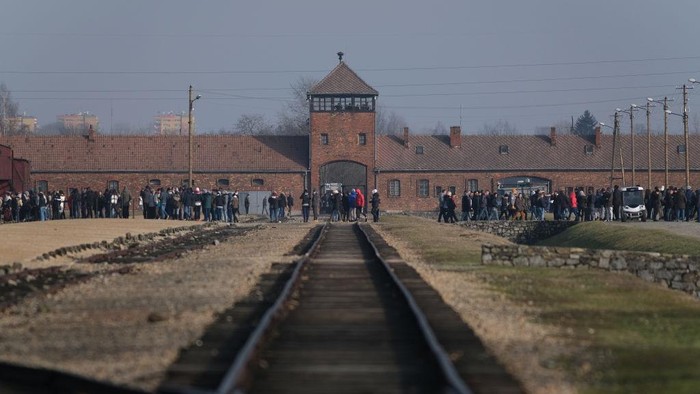 OSWIECIM, POLAND - FEBRUARY 15: Visitors walk past the entrance gate and original railway tracks, where arriving Jews were sorted between slave labor and the gas chambers, at the Auschwitz II-Birkenau memorial concentration camp site on February 15, 2019 in Oswiecim, Poland. Next year, 2020, will mark the 75th anniversary of the liberation of Auschwitz. The Nazis used the Auschwitz camp and its satellite camps for slave labor and large-scale extermination of arriving inmates. In all 1.1 million Jews and others died at Auschwitz between 1940 and 1945. (Photo by Sean Gallup/Getty Images)