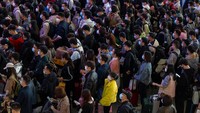 Pelancong mengenakan masker untuk membantu melindungi diri dari COVID-19 mengantre kereta di sebuah stasiun di Guangzhou di Provinsi Guangdong, China selatan, Jumat, (28/1/2022). Chinatopix via AP