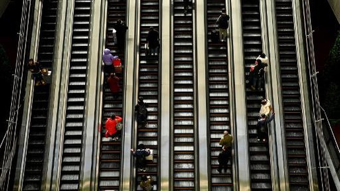 People use an escalator at a subway station in Beijing on January 27, 2022. (Photo by NOEL CELIS / AFP)