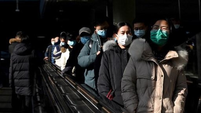Potret Stasiun Kereta Beijing Jelang Imlek People use an escalator at a subway station in Beijing on January 27, 2022. (Photo by NOEL CELIS / AFP)
