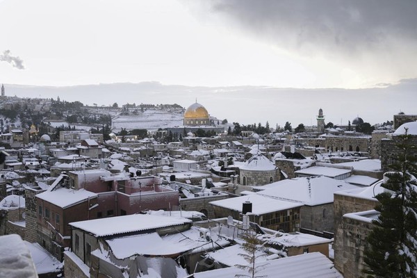 Salju langka menyelimuti Yerusalem dan beberapa tempat suci di area itu pada Kamis (27/1). Salju ini menutupi Kubah Batu Masjid Al-Aqsa yang dilapisi emas. (AP/Mahmoud Ilean)