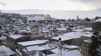 Salju langka menyelimuti Yerusalem dan beberapa tempat suci di area itu pada Kamis (27/1). Salju ini menutupi Kubah Batu Masjid Al-Aqsa yang dilapisi emas. (AP/Mahmoud Ilean)