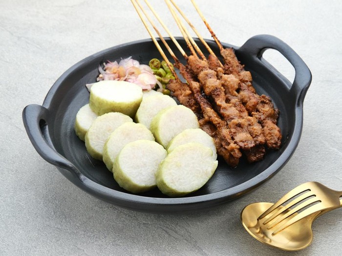 Chicken satay (sate ayam), Sate Ayam Madura with Lontong and peanut sauce. One of the popular street food in Indonesia