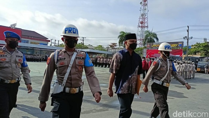 Bripka Bayu Tamtomo (pakai peci) dicopot dari kepolisian.