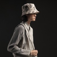 Rizal Rama mendapat kepercayaan untuk memeragakan look monokrom serba abu-abu yang terdiri dari kemeja dan celana panjang senada. Gayanya disempurnakan dengan tas Baguette Fendi yang ikonis, berikut kalung berlogo monogram FF, dan bucket hat. (Foto: Dok. Fendi)