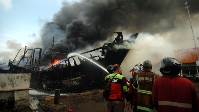 KAPAL TERBAKAR DI PELABUHAN TEGAL Sejumlah warga melihat kapal ikan yang terbakar di Pelabuhan Tegal, Jawa Tengah, Sabtu (29/1/2022). Sebanyak 13 kapal nelayan yang akan melaut terbakar sekitar pukul 04.30 WIB dan pihak terkait masih menyelidiki penyebab musibah tersebut. ANTARA FOTO/Oky Lukmansyah/nym.