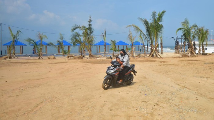 REKLAMASI DANAU SINGKARAK DIHENTIKAN Warga melintas di depan proyek reklamasi yang saat ini dihentikan di tepian Danau Singkarak, Kabupaten Solok, Sumatera Barat, Sabtu (29/1/2022). Kementerian Agraria dan Tata Ruang (ATR)/Badan Pertanahan Nasional (BPN) memberi tenggat waktu selama empat bulan bagi Pemkab Solok untuk membongkar reklamasi Danau Singkarak yang juga disorot KPK itu, karena dinilai menyalahi aturan dan menyebabkan kerugian negara. ANTARA FOTO/Iggoy el Fitra/nym.