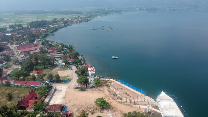 REKLAMASI DANAU SINGKARAK DIHENTIKAN Warga melintas di depan proyek reklamasi yang saat ini dihentikan di tepian Danau Singkarak, Kabupaten Solok, Sumatera Barat, Sabtu (29/1/2022). Kementerian Agraria dan Tata Ruang (ATR)/Badan Pertanahan Nasional (BPN) memberi tenggat waktu selama empat bulan bagi Pemkab Solok untuk membongkar reklamasi Danau Singkarak yang juga disorot KPK itu, karena dinilai menyalahi aturan dan menyebabkan kerugian negara. ANTARA FOTO/Iggoy el Fitra/nym.