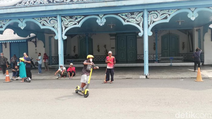 Wisatawan menggunakan skuter listrik saat berkunjung ke Keraton Kasunanan Solo.