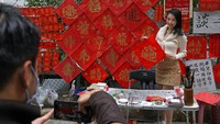 Seorang warga menunjukkan Fai Chun yang bertuliskan Keberuntungan Baik di Hong Kong, Rabu (26/1/2022).