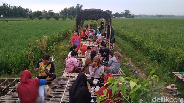 Pengunjung menikmati Pasar Tiban Pinggir Sawah di Cepu, Blora, (30/1/2022).