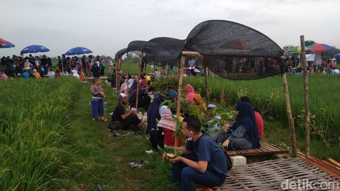 Pengunjung menikmati Pasar Tiban Pinggir Sawah di Cepu, Blora, (30/1/2022).