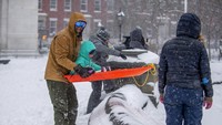 Kawasan New York yang diselimuti salju tebal itu pun dimanfaatkan sejumlah warga untuk bermain. Tak sedikit orang dewasa yang mengajak serta anak-anaknya bermain salju di Washington Square Park. AP Photo/Brittainy Newman. 