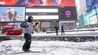 Seorang warga asyik bermain ski di kawasan New York Times Square saat area tersebut diselimuti salju tebal akibat diterjang badai salju, Sabtu (29/1/2022) waktu setempat. AP Photo/Mary Altaffer.