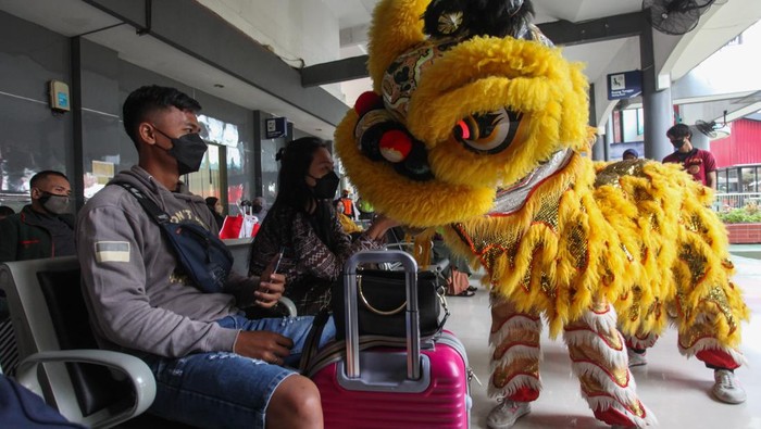 Calon penumpang berinteraksi dengan Barongsai di Stasiun Gubeng Surabaya, Jawa Timur, Senin (31/1/2022). Atraksi Barongsai itu bertujuan untuk menghibur penumpang kereta api sekaligus untuk menyambut Tahun Baru Imlek. ANTARA FOTO/Didik Suhartono/rwa.