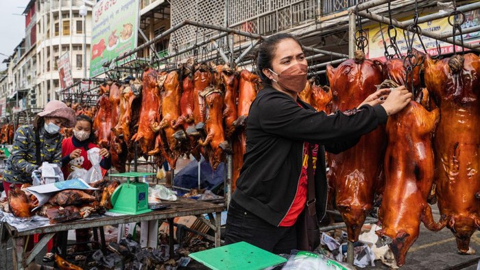 PHNOM PENH, CAMBODIA - JANUARY 31: Vendors sell roasted pigs at a market on January 31, 2022 in Phnom Penh, Cambodia. Cambodia prepares to celebrate the Lunar New Year as the government took phased steps to reopen borders over the preceding months, including welcoming vaccinated tourists to the country.  (Photo by Cindy Liu/Getty Images)