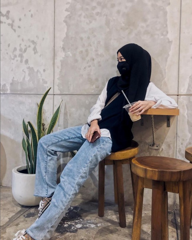 Adiba tampil casual saat berada di coffee shop. Adiba menjadikan vest hitam sebagai luaran dipadu dengan kemeja putih, celana jeans dan sepatu converse. Foto: Dok. Instagram @adiba.knza.