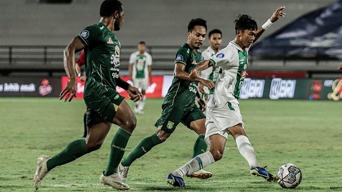 Pemain PSS Sleman (hijau putih) berjibaku saat melawan Persebaya Surabaya, Sabtu (29/1/2022).