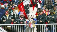 Pendukung tim ski Austria membuat musik dengan Powder salah satu maskot Olimpiade Musim Dingin Salt Lake City saat mereka menunggu dimulainya cuaca yang tertunda menuruni bukit wanita di Snowbasin, Utah, (11/2/2002). (AP Photo/Rudi Blaha)