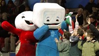 Anak-anak yang menghadiri perlombaan skating trek pendek di Palavela Arena bersorak dengan maskot Olimpiade Torino Neve, kiri dan Gliz pada Olimpiade Musim Dingin 2006 di Turin, Italia, (15/2/2006). (AP Photo/Amy Sancetta)