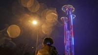 Menara Olimpiade Beijing 2022 terlihat di ibu kota China itu, Minggu (30/1/2022). Pendar lampu kota dengan efek cahaya memberi tahu napas kota belum selesai. The show must go on. (AP Photo/Andy Wong)