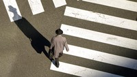 Pejalan kaki di persimpangan jalan Kota Tokyo, Senin (31/1/2022). Pandemi tidak menawarkan banyak pilihan. Seperti hidup yang terantuk persimpangan jalan, ke kiri atau ke kanan, take it or leave it. (AP Photo/Eugene Hoshiko)