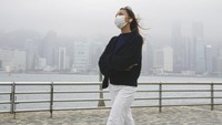 Perempuan melihat langit dengan latar Kota Hong Kong yang berkabut, Jumat (28/1/2022). Harapan selalu ada. (AP Photo/Kin Cheung)
