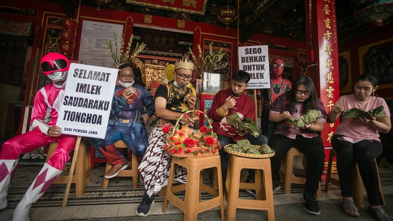 Warga dengan mengenakan kostum pewayangan dan superhero bertukar nasi berkat dengan kue keranjang di Klenteng Tien Kok Sie, Pasar Gede, Solo, Jawa Tengah, Senin (31/1/2022). Aksi tersebut dalam rangka memberikan ucapan 
