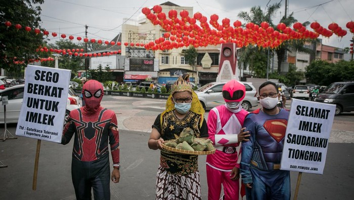 Warga dengan mengenakan kostum pewayangan dan superhero bertukar nasi berkat dengan kue keranjang di Klenteng Tien Kok Sie, Pasar Gede, Solo, Jawa Tengah, Senin (31/1/2022). Aksi tersebut dalam rangka memberikan ucapan 