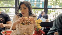 No diet today, tulis Siwi Widi di keterangan foto. Ia terlihat santai di kafe mewah sambil menikmati sandwich tebal dan cocktail buah.