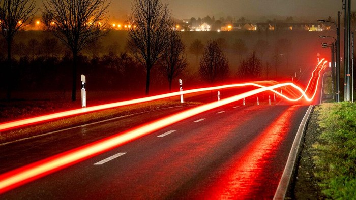 A long exposure photo shows the back lights of a car driving on a road, on the outskirts of Frankfurt, Germany, early Tuesday, Dec. 28, 2021. (Photo/Michael Probst)