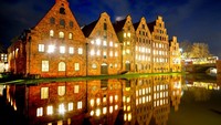 Lampu menyala di gudang bersejarah abad pertengahan di Luebeck, Jerman utara, Kamis malam, (6/1/2022). Dengan teknik refleksi, foto gudang nampak lebih berseni.