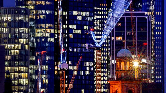 Cranes move near the buildings of the banking district in Frankfurt, Germany, Tuesday, Jan. 18, 2022. (AP Photo/Michael Probst)