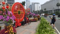 Warga berfoto dengan latar belakang ornamen bernuansa Imlek yang di pasang di kawasan Bundaran Hotel Indonesia, Jakarta, sejak Minggu (30/1/2022). Foto: ANTARA FOTO/Akbar Nugroho Gumay.