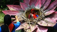 Pengunjung melakukan swafoto di wahana rumah bunga di Taman Wisata Tawun, Ngawi, Jawa Timur, Selasa (1/2/2022). Sejumlah wisatawan memanfaatkan libur tahun baru Imlek dengan mengunjungi taman wisata yang mengandalkan keasrian hutan kota dan kesegaran sumber mata air tersebut. ANTARA FOTO/Ari Bowo Sucipto.