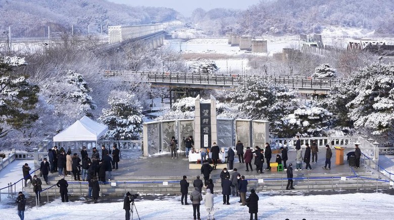 Potret Perayaan Imlek di Perbatasan Korsel-Korut People read messages on ribbons placed on a barbed wire fence, wishing for the reunification of the two Koreas, as they visit the Imjingak Pavilion near the border with North Korea, to celebrate the Lunar New Year in Paju, South Korea, Tuesday, Feb. 1, 2022. (AP Photo/Ahn Young-joon)