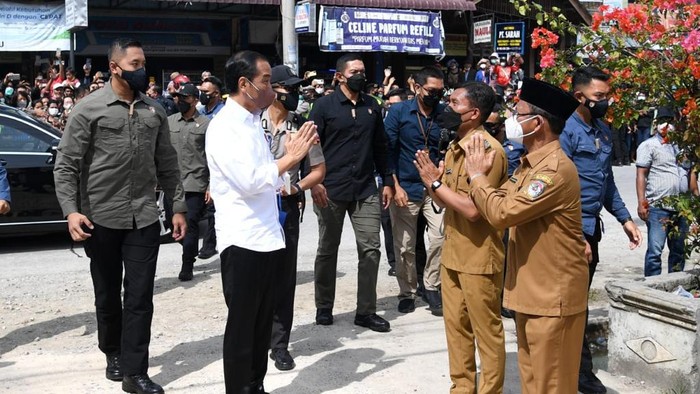 Presiden Joko Widodo membagikan bantuan langsung tunai bagi para pedagang kaki lima dan warung di Pasar Porsea, Kabupaten Toba, Provinsi Sumatera Utara, pada Rabu, (2/2/2022).