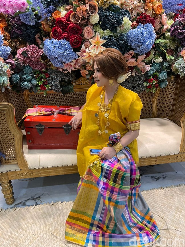 Dalam foto yang diunggah terlihat calon pengantin wanita tampil flawles dan cantik dengan mengenakan satu set baju bodo dan sarung warna kuning. Dekorasi acara mappettuada dihiasi oleh berbagai bunga cantik aneka warna. Menurut Beank, selain dihadiri oleh kerabat dan keluarga terdekat, acara mappettuada dihadiri oleh anggota dewan DPRD dari Malangke Barat, Sulawesi Selatan. Foto: Dok. pribadi Beank.
