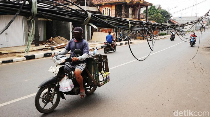 Kabel Semrawut di Bekasi Ini Bahayakan Pengendara Pengendara melintas di Perempatan Embeh, Jalan Pangkalan II Bantargebang Kota Bekasi, Rabu (2/2/2022). Keberadaan kabel utilitas yang menjuntai di jalan dikeluhkan pengendara.